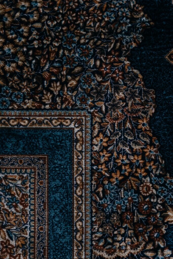 pexels-photo-6786956-6786956 Elegant and detailed ornate carpet design captured from a top view angle, showcasing intricate patterns and rich textures.